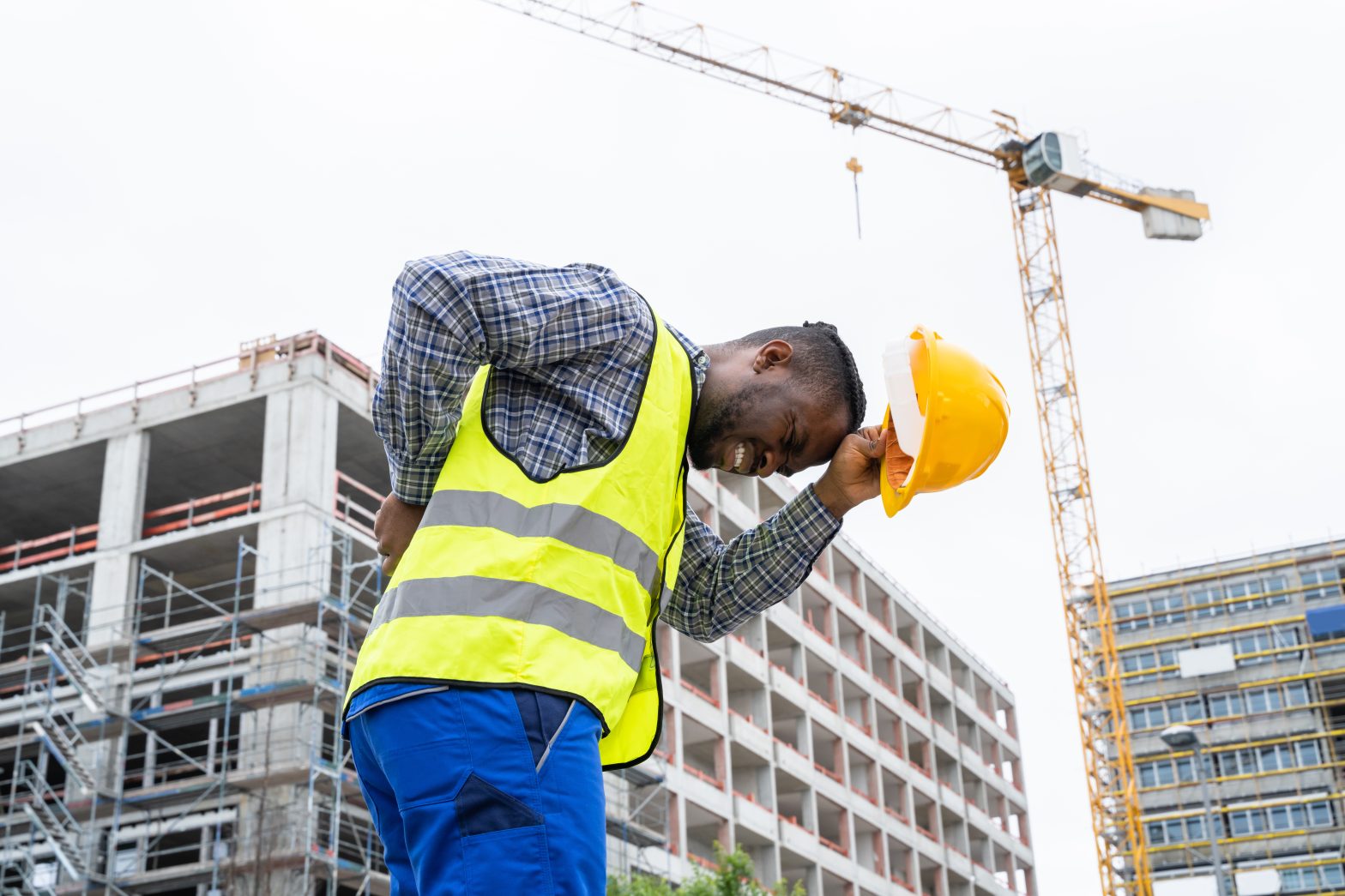 A man working construction on the job and suffering from back pain to represent Worker's Comp Claims Suffolk.